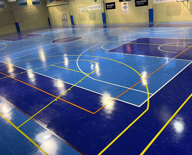 Pista de baloncesto y futbol sala creada en en pavimento continuo de color azul y celeste